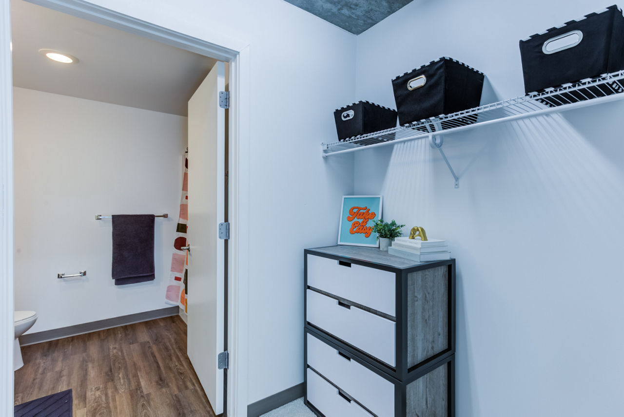 Modern bathroom featuring a geometric shower curtain and wood-style flooring in luxury apartments