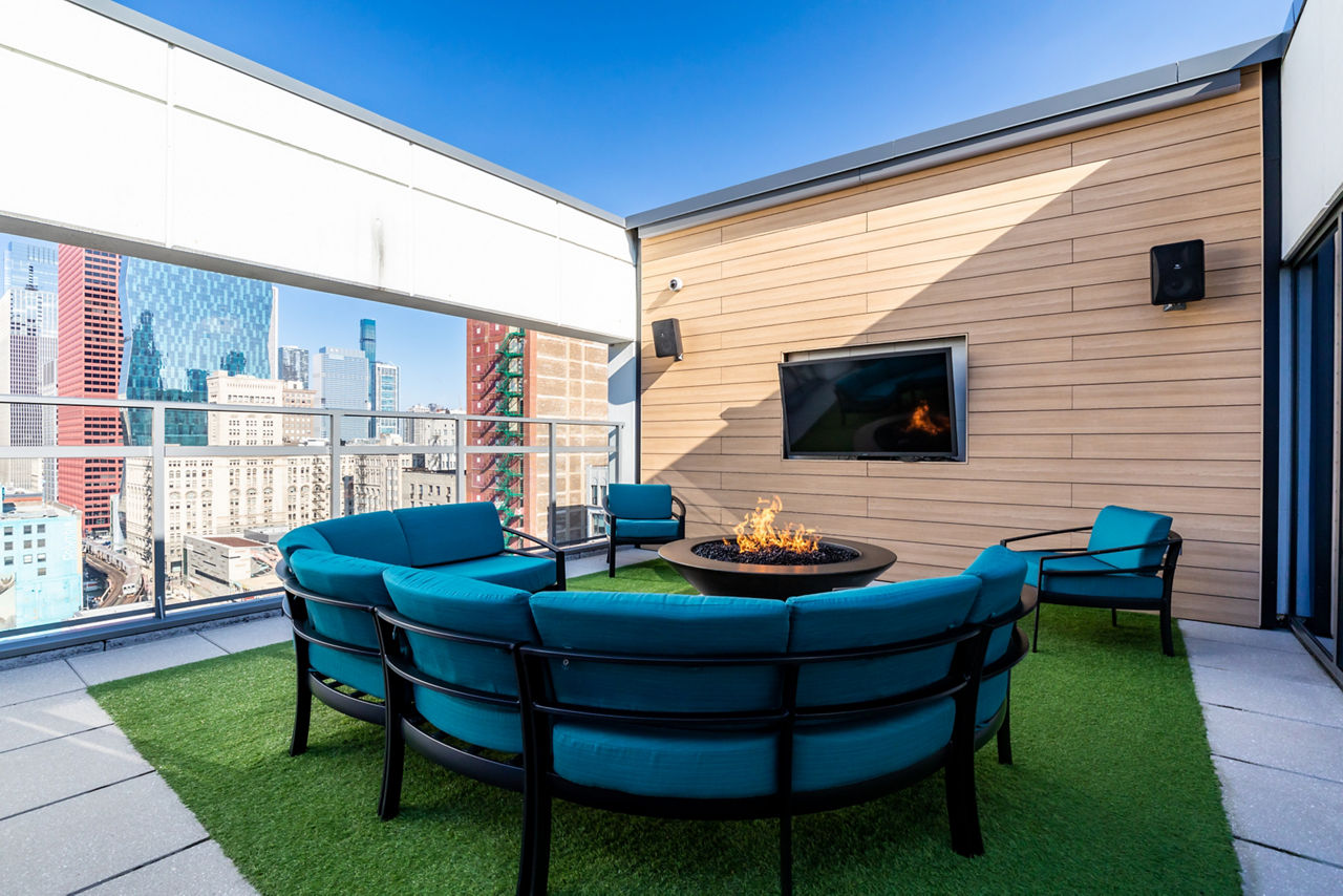Modern outdoor patio with seating and a cozy fireplace at luxury apartments