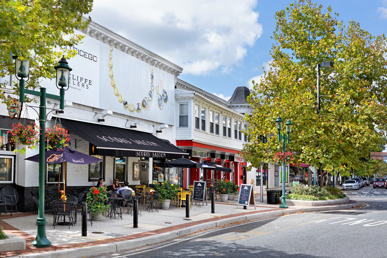 Vibrant neighborhood view near Flats at 703 Apartments featuring tree-lined streets and community areas