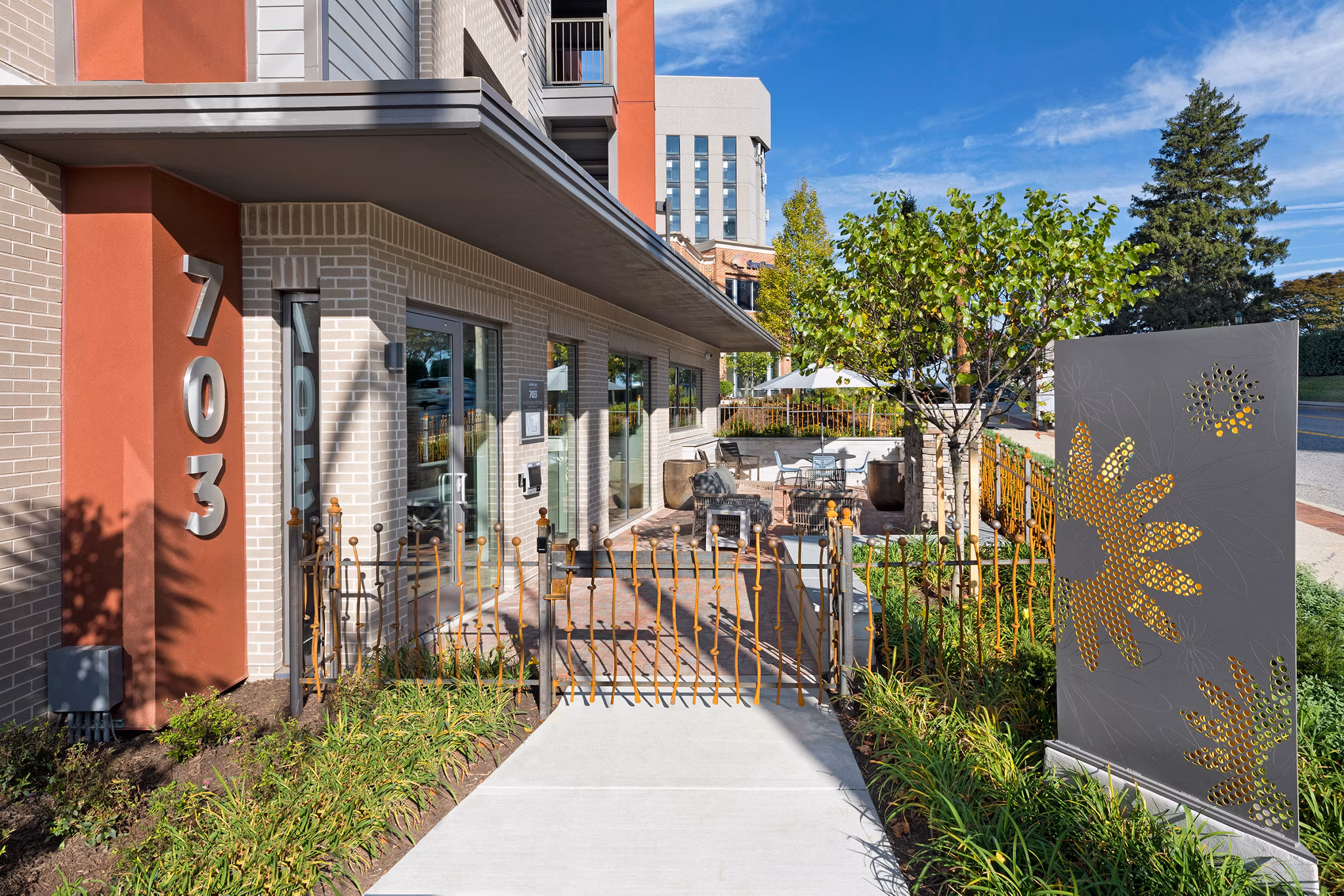 Tranquil courtyard with lush greenery at Flats at 703 Apartments, offering a serene outdoor space for residents to relax and enjoy nature