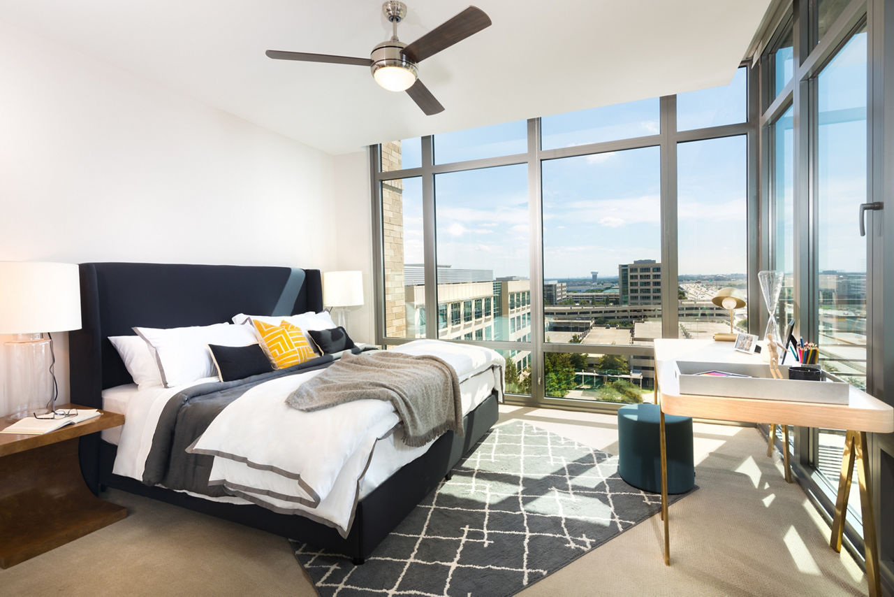 Cozy bedroom with modern decor at The Kincaid at Legacy Apartments, featuring plush bedding and ample natural light