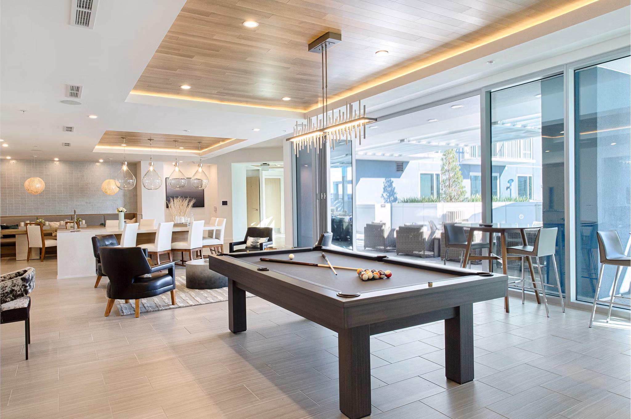 Modern game room with pool table and arcade games at Nine15 Apartments, offering fun and relaxation in a vibrant community setting