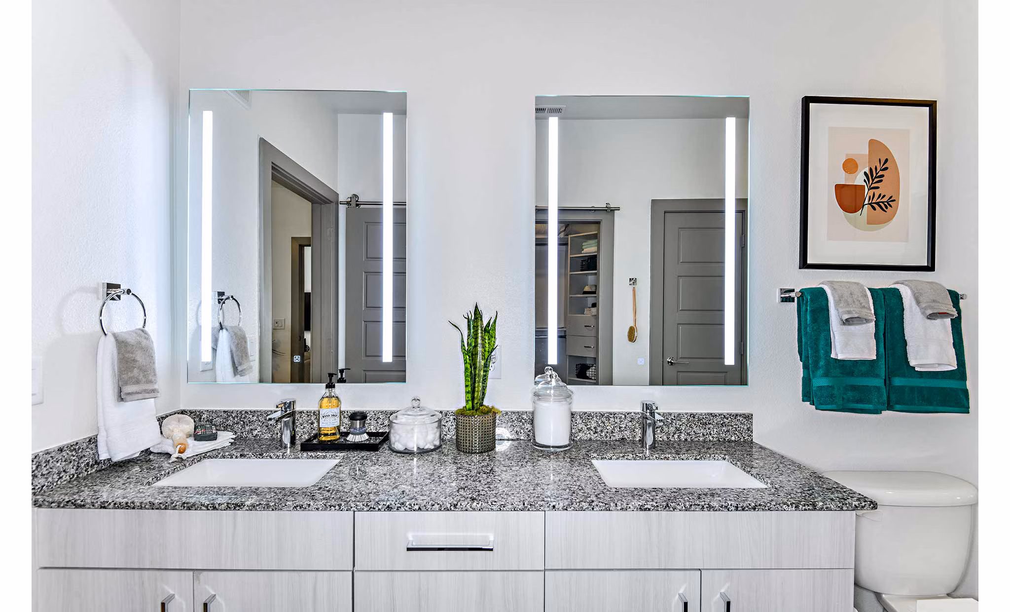 Modern bathroom with marble countertops and glass shower at The Jamison Apartments