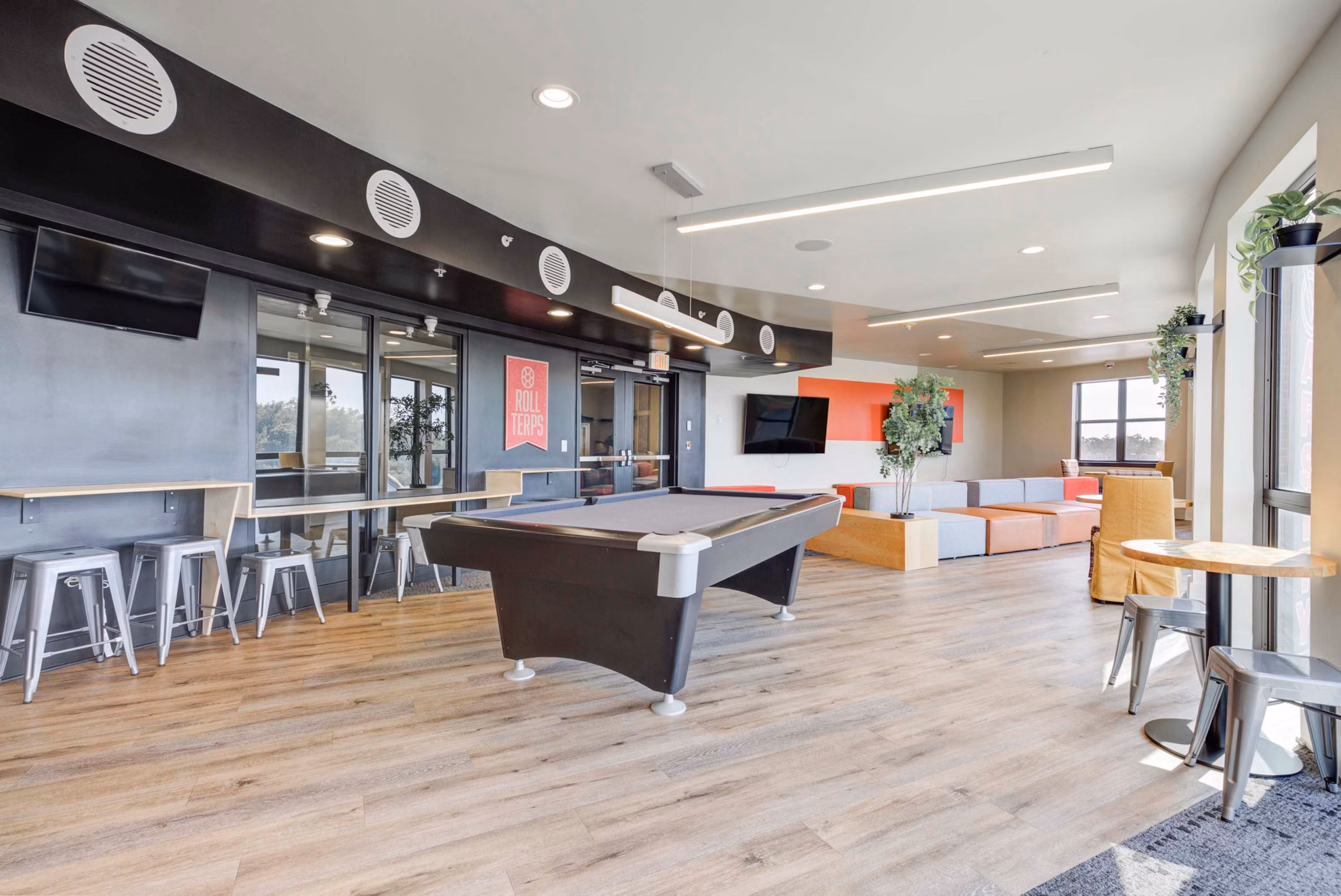 Game room featuring pool tables and lounge area at The Varsity Apartments