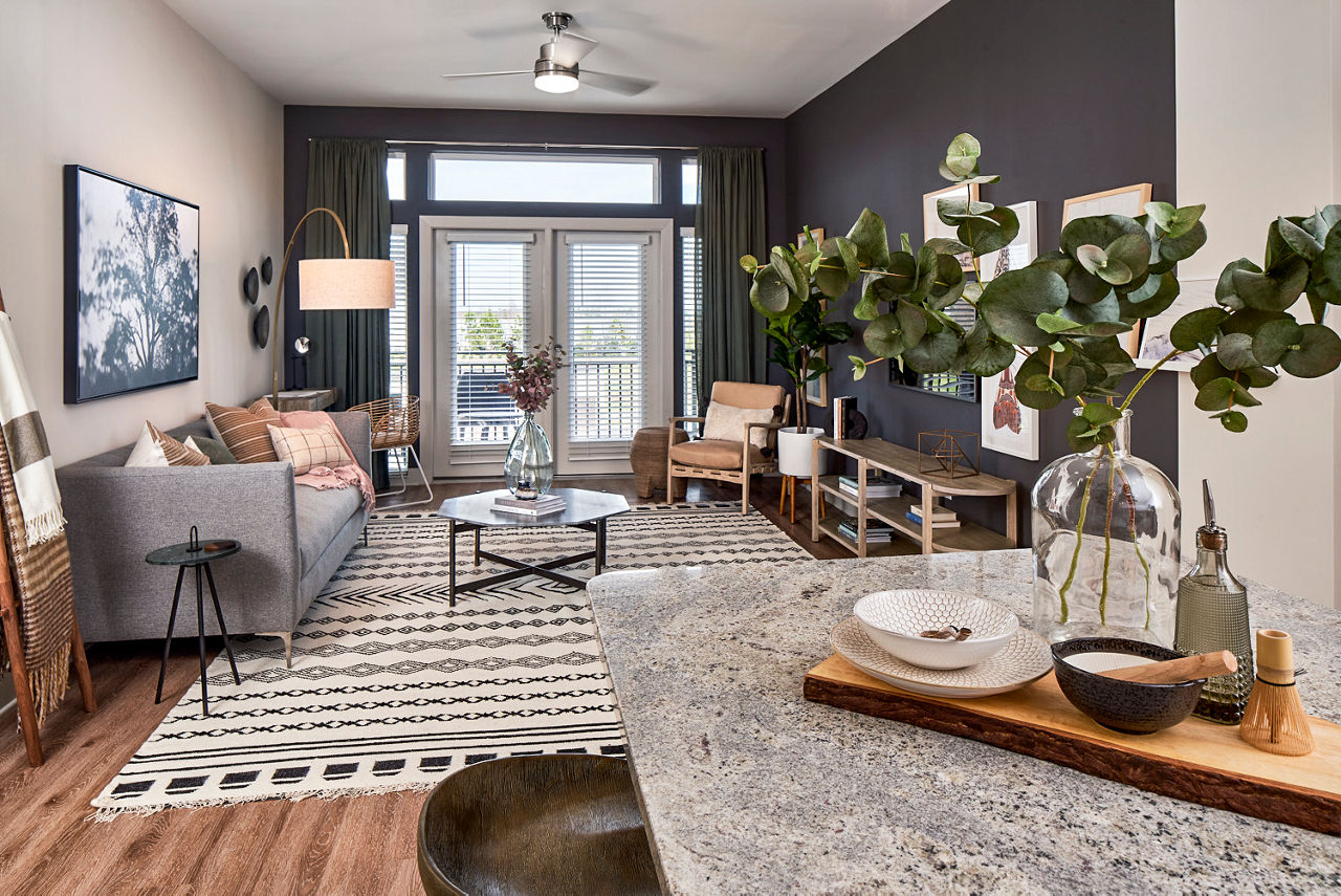 Living room with modern furnishings and large windows at The Court at Redstone Apartments