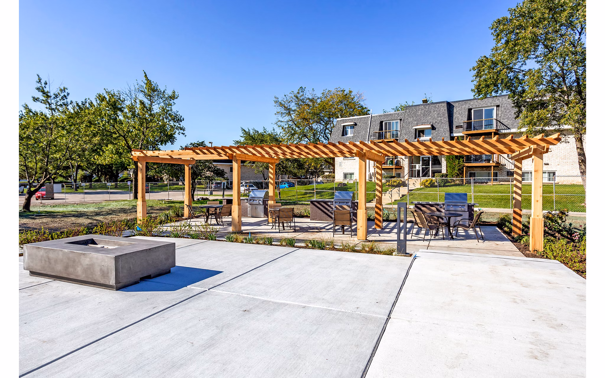 Outdoor grill area with modern seating at Orion Parkview Apartments, perfect for gatherings and barbecues in a serene setting