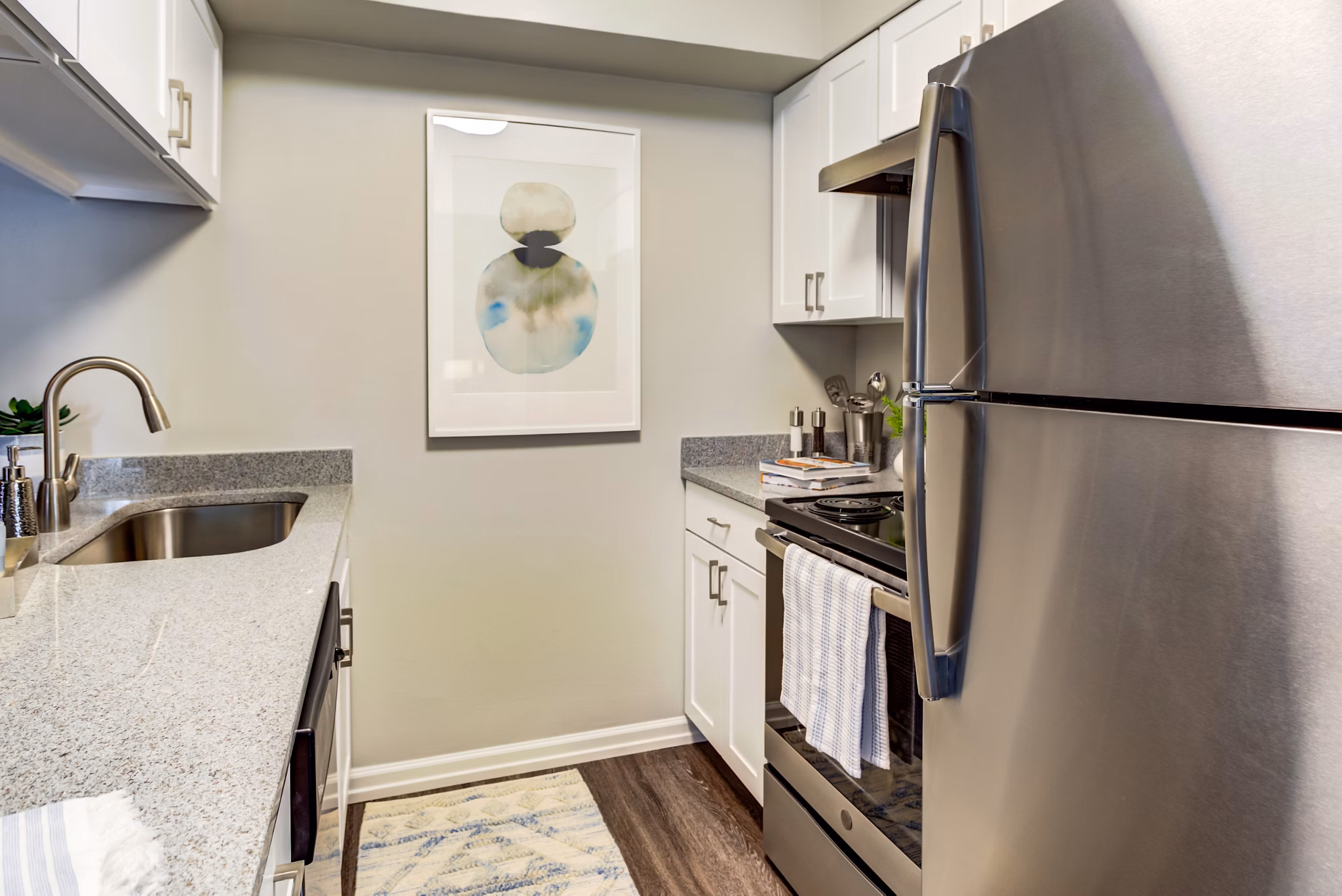 Sleek kitchen with stainless steel appliances and granite countertops at Orion Prospect Apartments