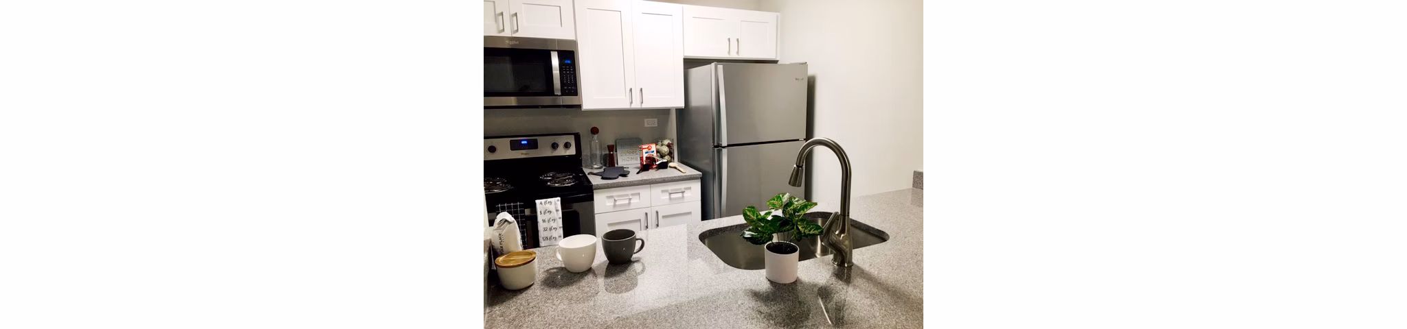 Modern kitchen with sleek cabinetry and stainless steel appliances at Orion 59 Apartments