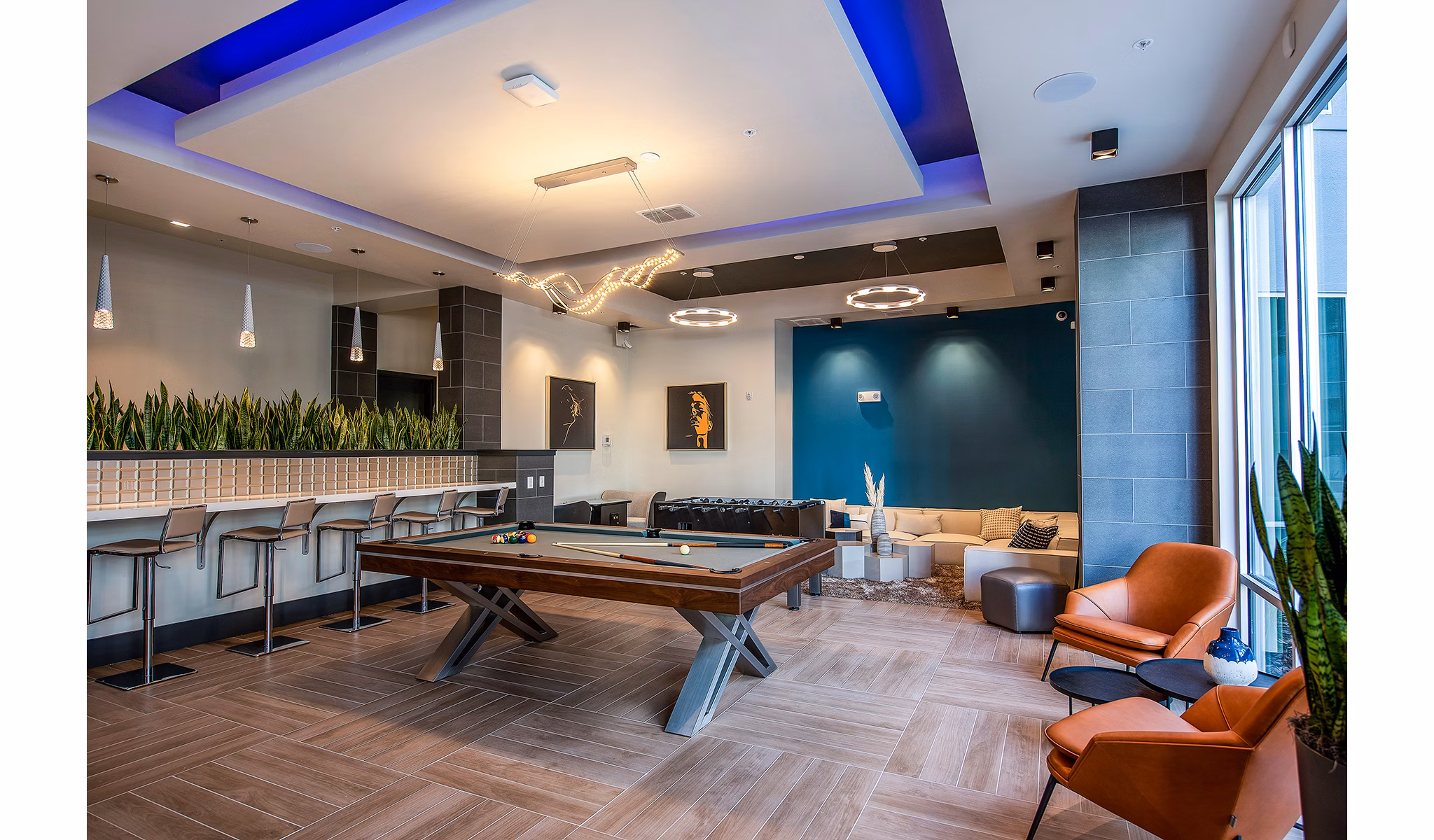 Game room with pool table and lounge chairs at Sanctuary at Centerpointe Apartments