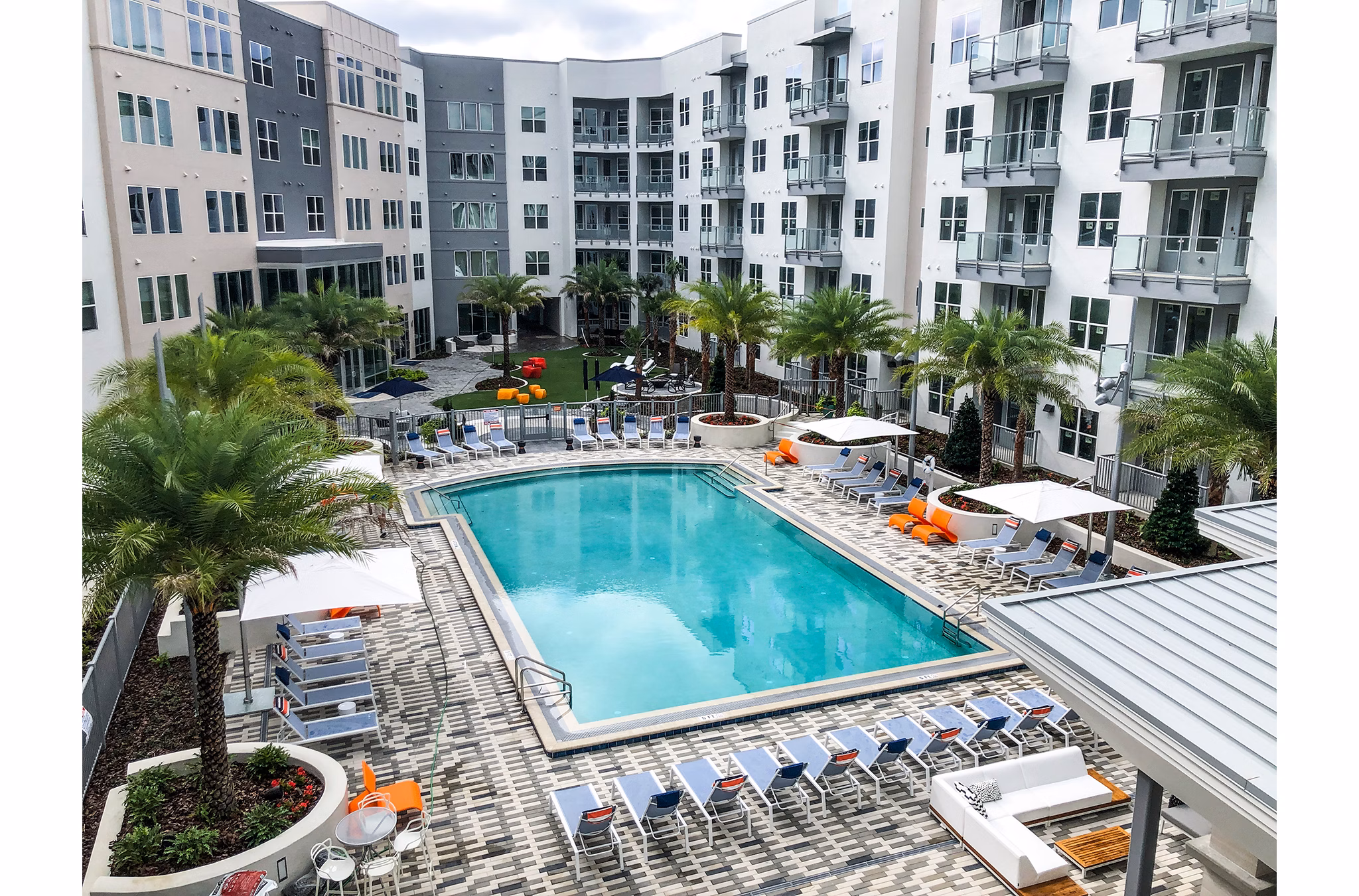Resort-style pool at Sanctuary at Centerpointe Apartments with surrounding lounge chairs and landscaped gardens