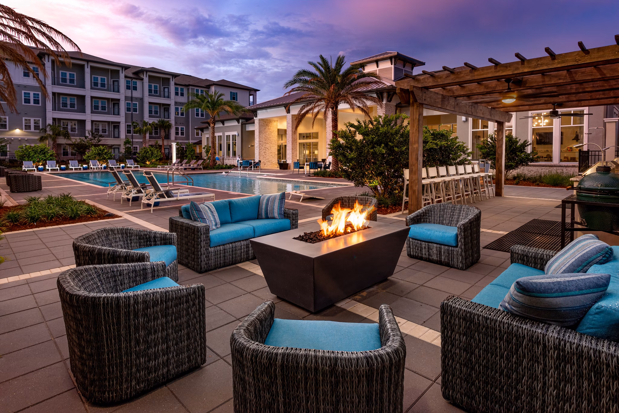 Outdoor fire pit area with seating at Overture Hamlin Apartments, ideal for social gatherings and relaxation in a luxurious community setting