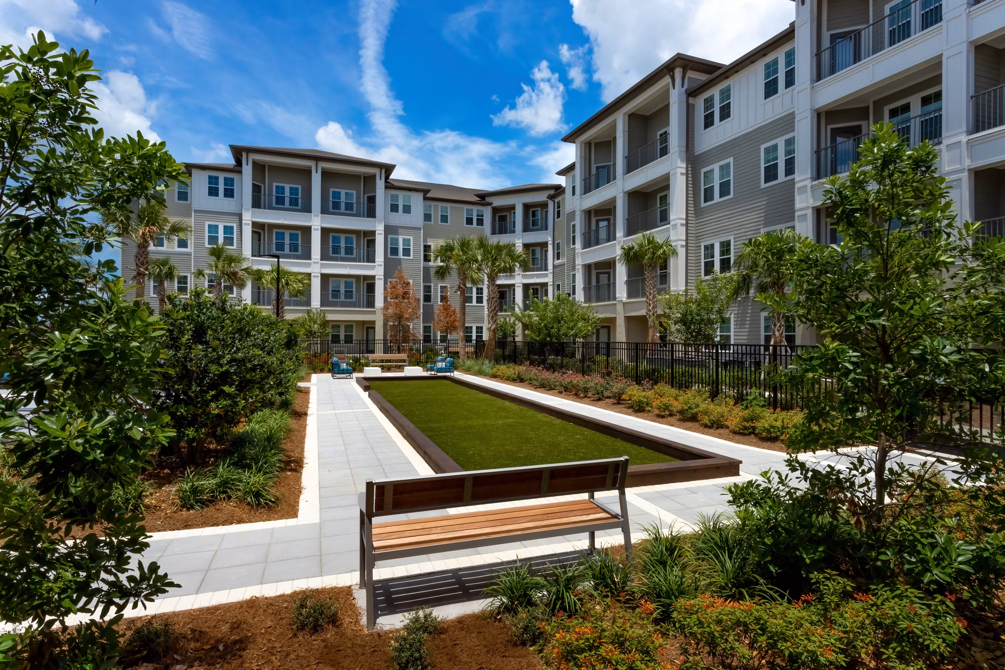 Overture Hamlin: Tranquil courtyard with lush greenery and seating areas, a serene retreat at luxury apartments in Orlando