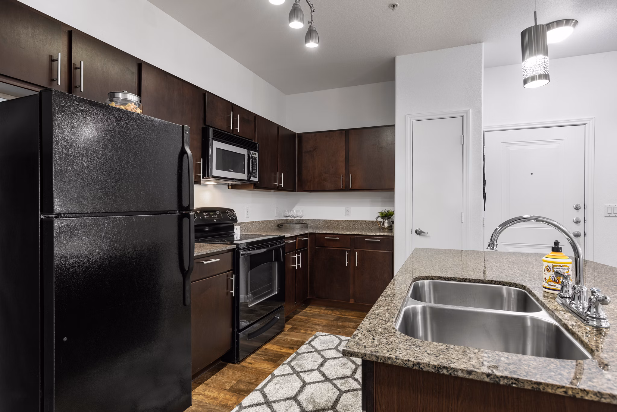 Modern kitchen featuring stainless steel appliances and granite countertops at The Oaks at Techridge Apartments
