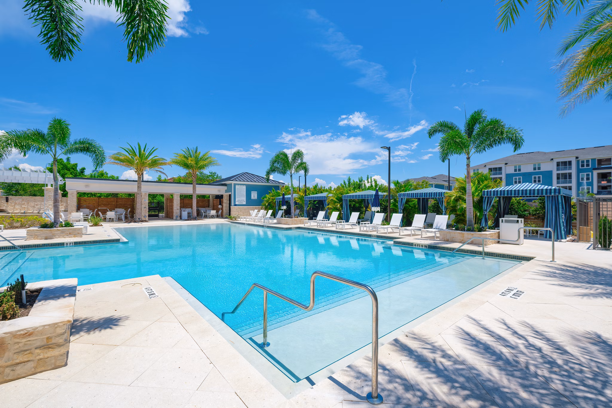 Expansive swimming pool with sun loungers at Vue at Belleair Apartments, luxury living redefined