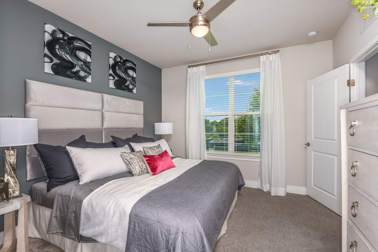 Cozy bedroom with modern furnishings at The Lodge at Hamlin Apartments featuring luxury living amenities