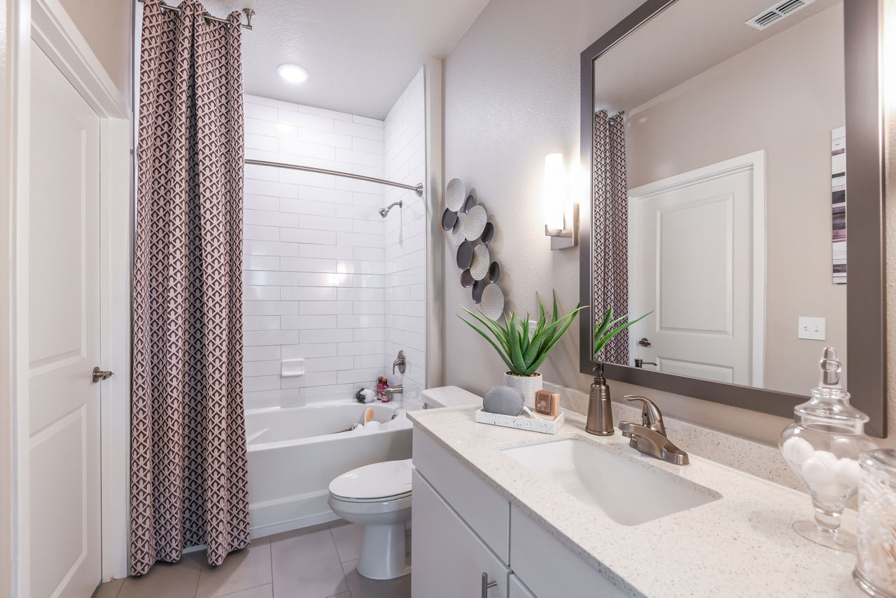 Bathroom featuring modern fixtures and double vanity at The Lodge at Hamlin Apartments