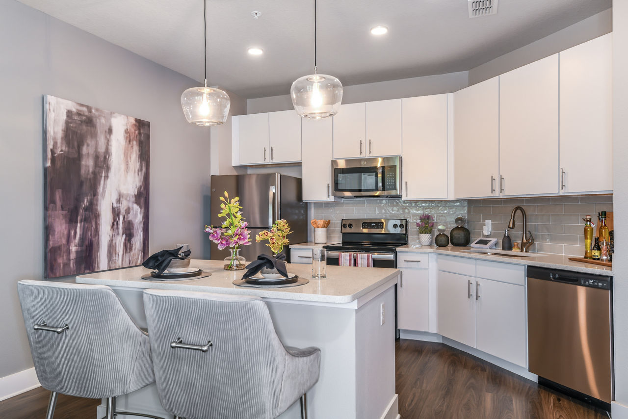 Modern kitchen with stainless steel appliances and granite countertops at The Lodge at Hamlin Apartments