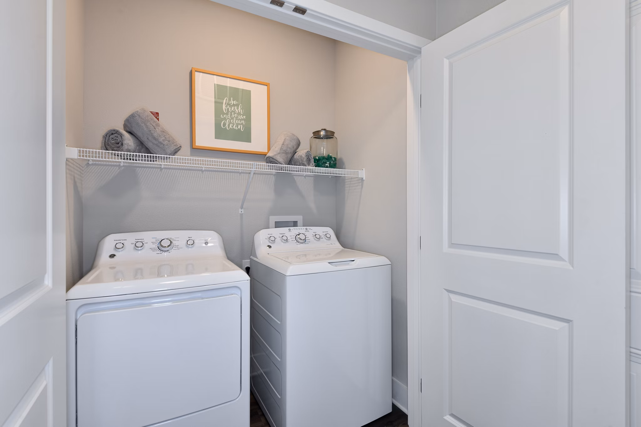 Laundry room with modern washers and dryers in The Lodge at Hamlin Apartments