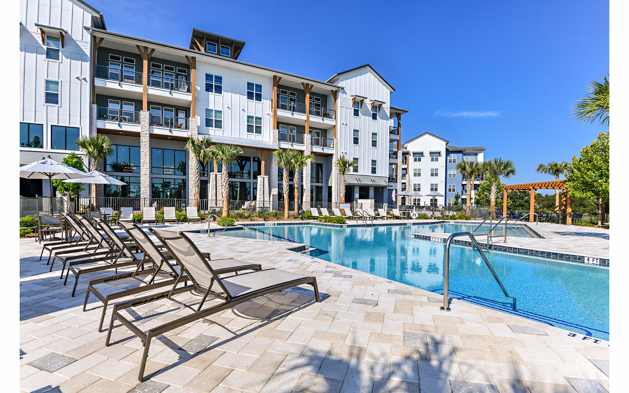 The Lodge at Hamlin: Luxury pool with lounge chairs and greenery at Greystar apartments in desirable area