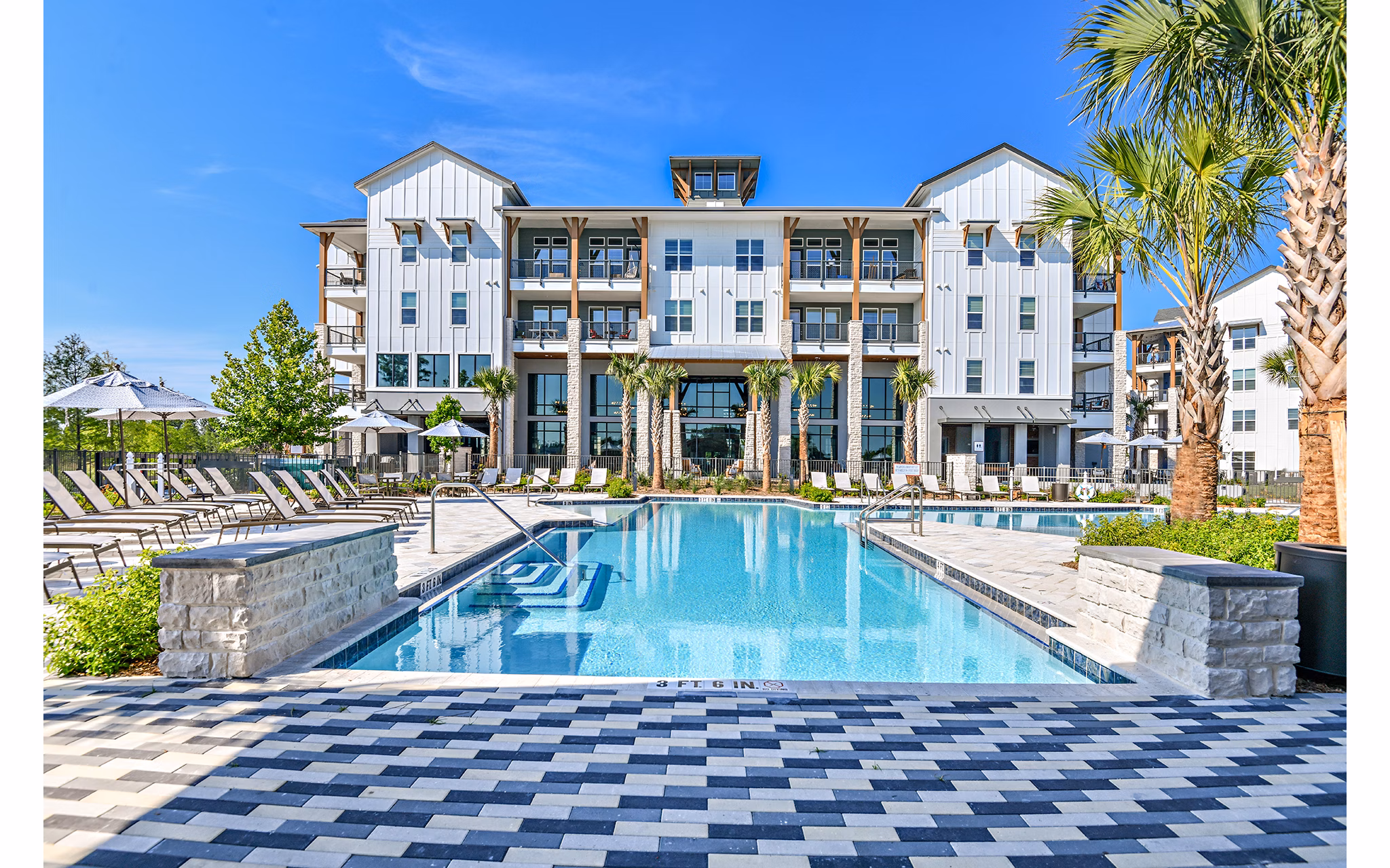 Inviting swimming pool with sun loungers at The Lodge at Hamlin Apartments, offering a relaxing oasis for residents