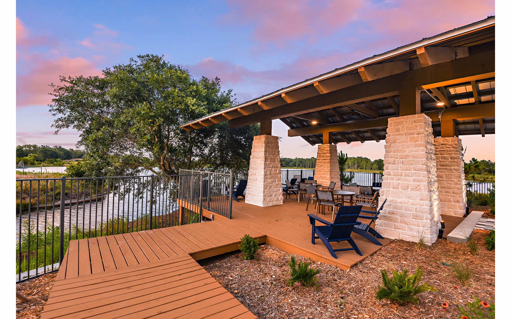 Patio with modern seating and lush greenery at The Lodge at Hamlin Apartments, offering a serene outdoor space for relaxation and leisure