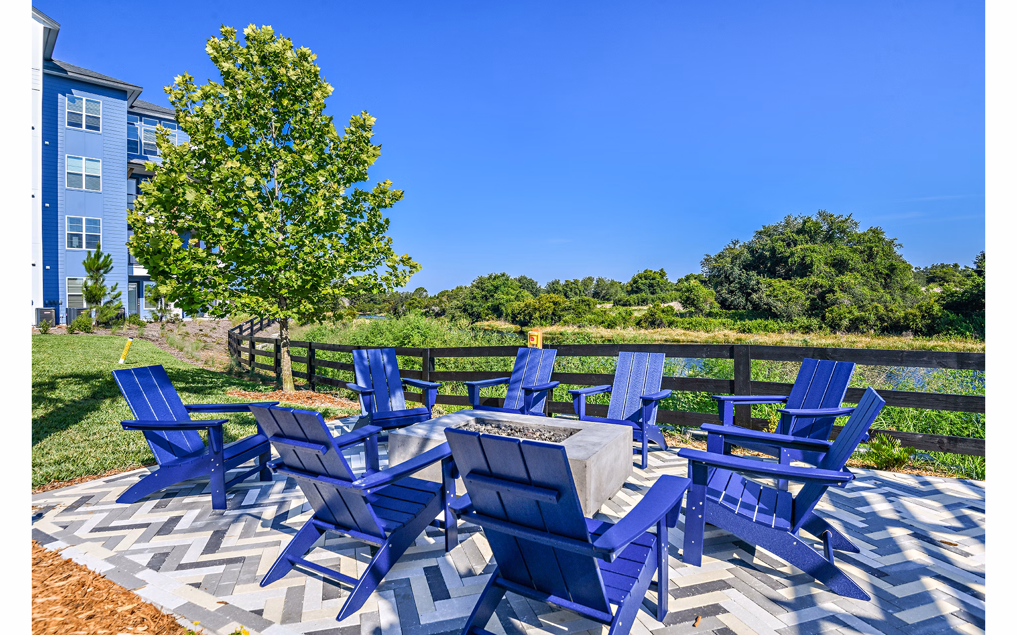 Fire pit surrounded by cozy seating at The Lodge at Hamlin Apartments