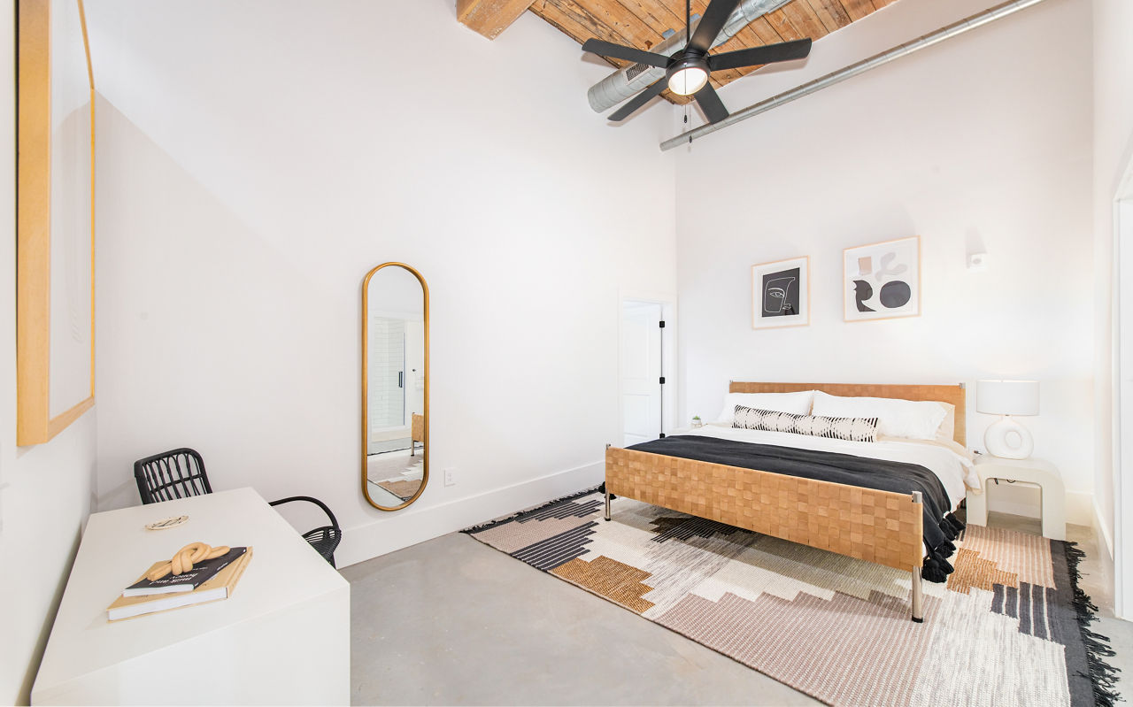 Cozy bedroom with modern furniture at The Lofts at Woodside Mill Apartments, showcasing stylish urban living