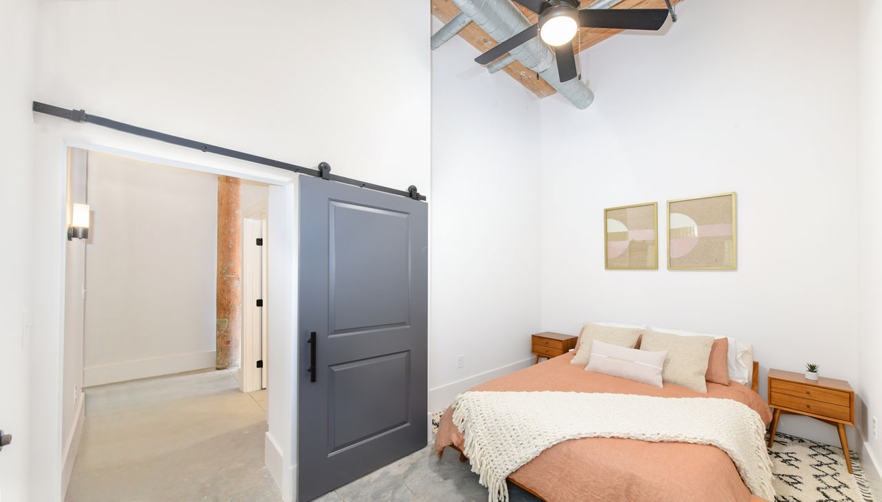 Modern bedroom with industrial design accents at The Lofts at Woodside Mill Apartments
