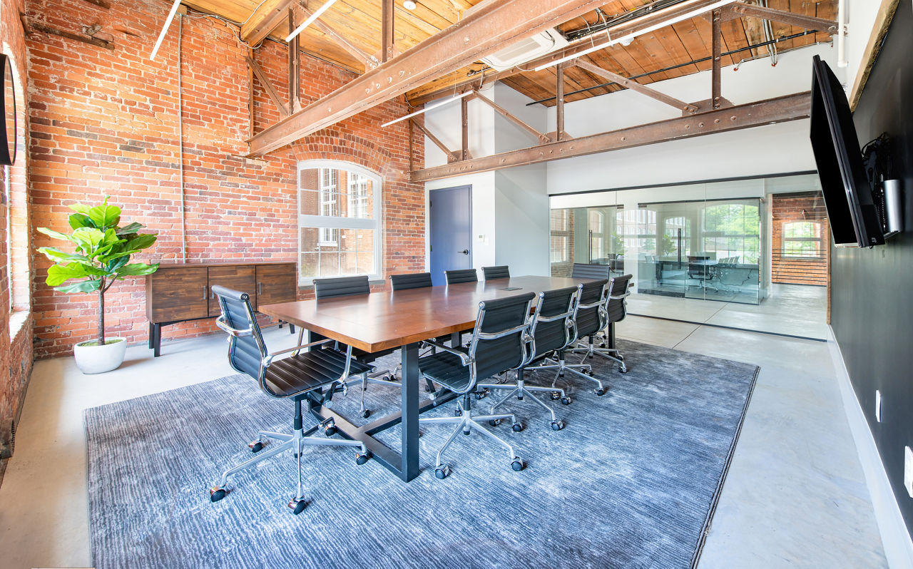 Meeting facility with modern seating and presentation equipment at The Lofts at Woodside Mill Apartments Perfect for business gatherings and events