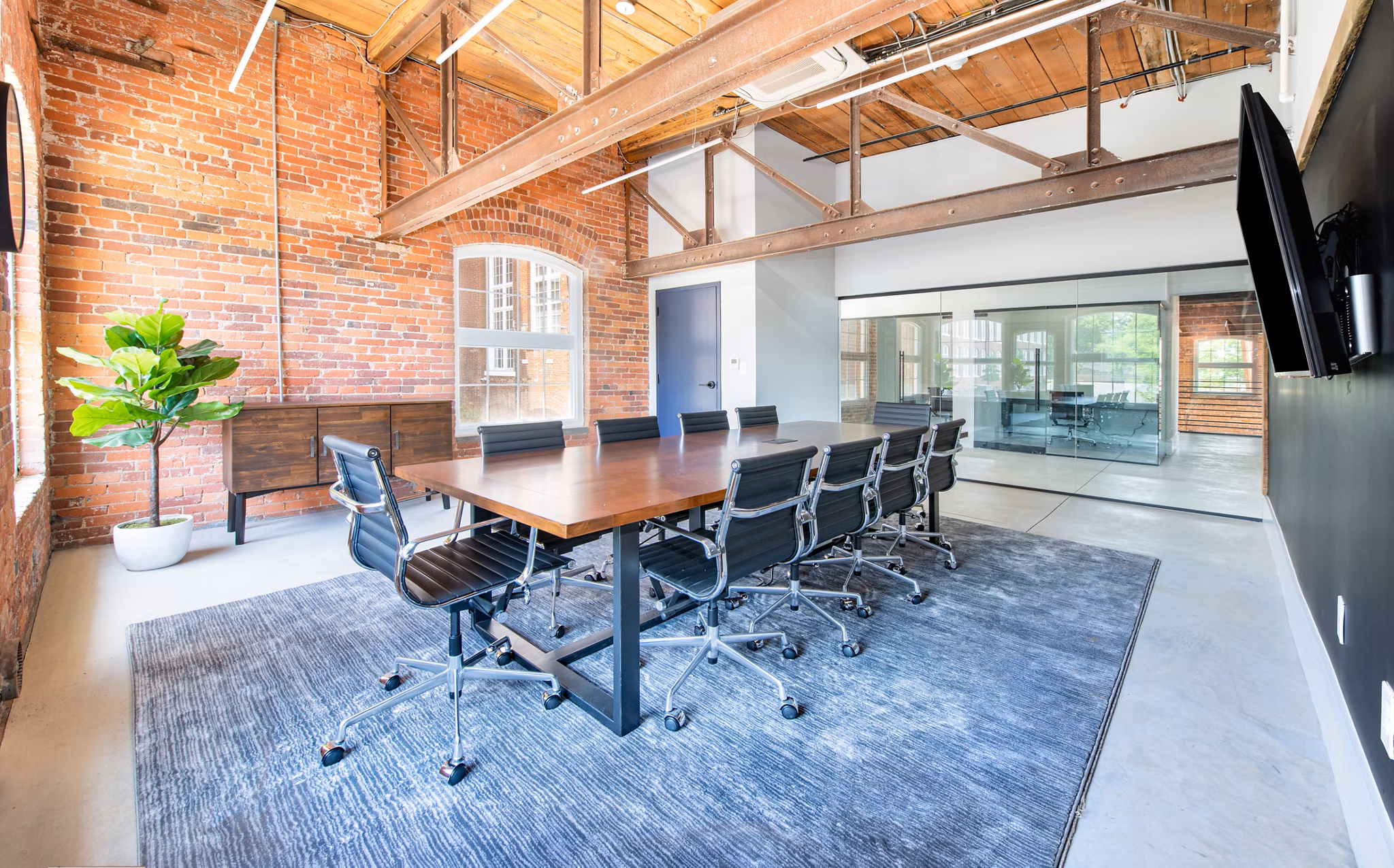 Meeting facility with modern seating and presentation equipment at The Lofts at Woodside Mill Apartments Perfect for business gatherings and events