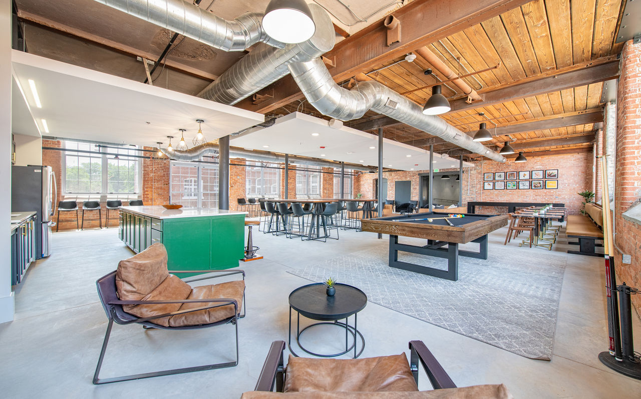 Clubhouse featuring modern decor and ample seating at The Lofts at Woodside Mill Apartments