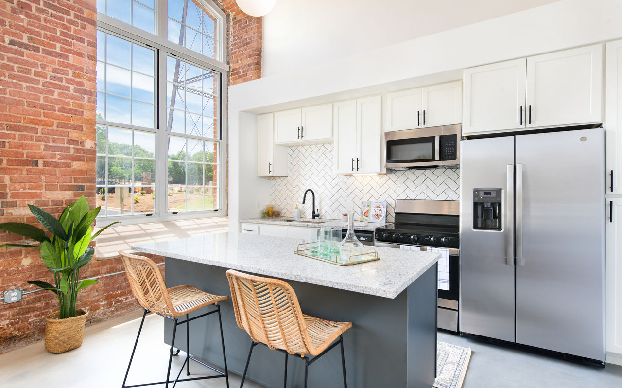 Modern kitchen with stainless steel appliances at The Lofts at Woodside Mill Apartments