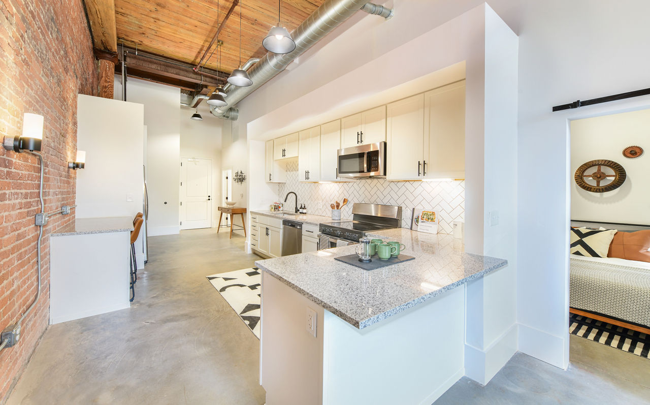 Modern kitchen with sleek cabinetry and stainless steel appliances at The Lofts at Woodside Mill Apartments