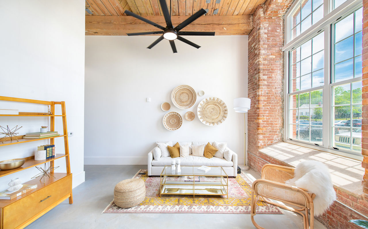 Spacious living area with exposed brick and modern furnishings at The Lofts at Woodside Mill Apartments