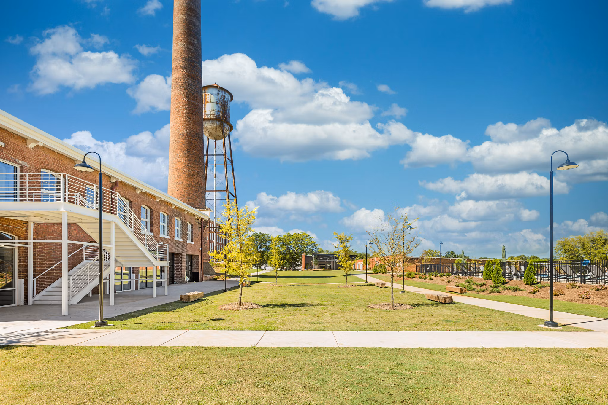 Courtyard with lush greenery and seating areas at The Lofts at Woodside Mill Apartments