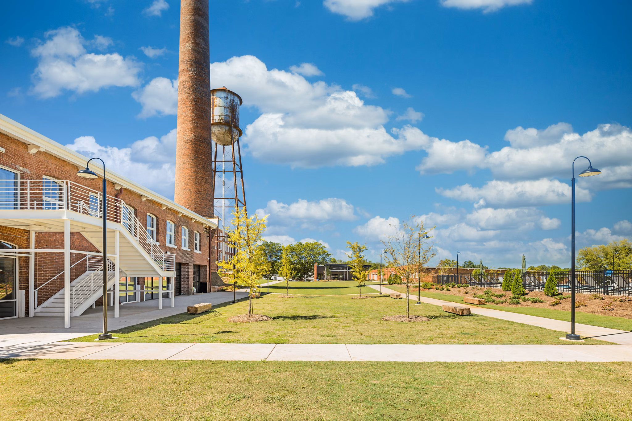 Courtyard with lush greenery and seating areas at The Lofts at Woodside Mill Apartments