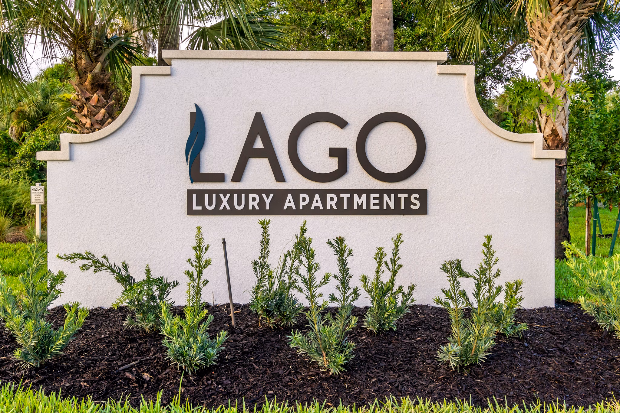 Lago Apartments signage in vibrant garden setting, San Francisco