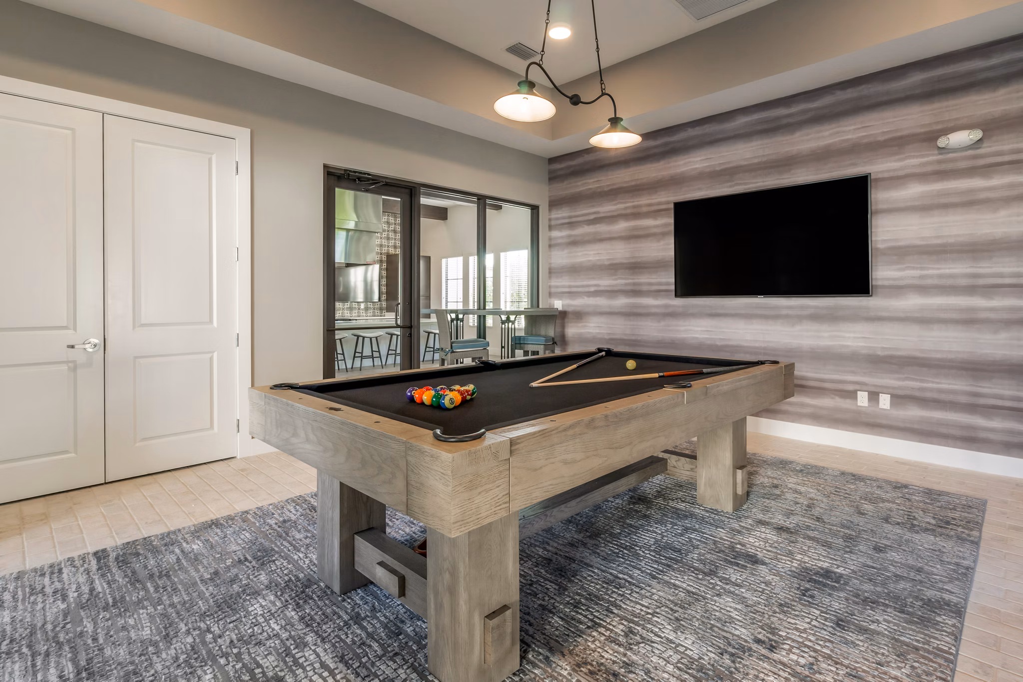 Vibrant game room with pool table and lounge seating at Lago Apartments