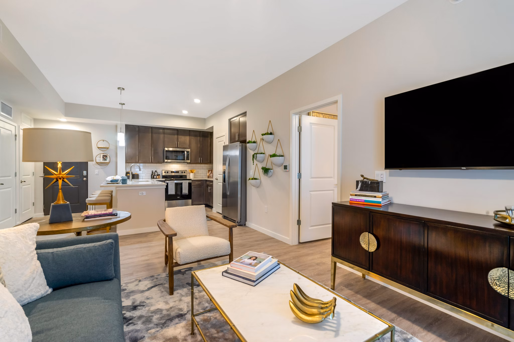 Spacious living room with modern decor at Lago Apartments with cozy seating and large windows offering natural light