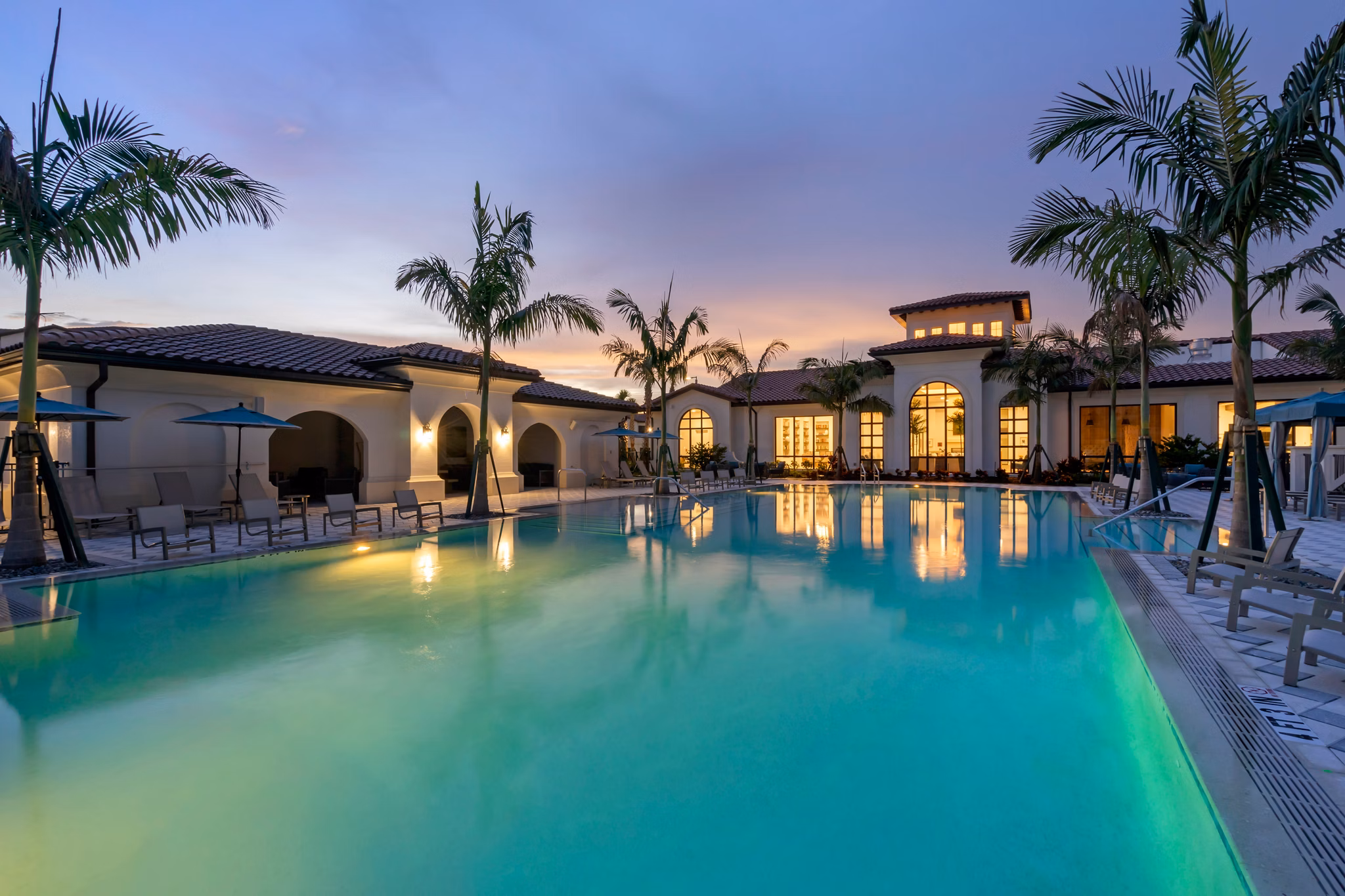 Resort-style pool at Lago Apartments luxury complex with sun loungers and landscaped surroundings