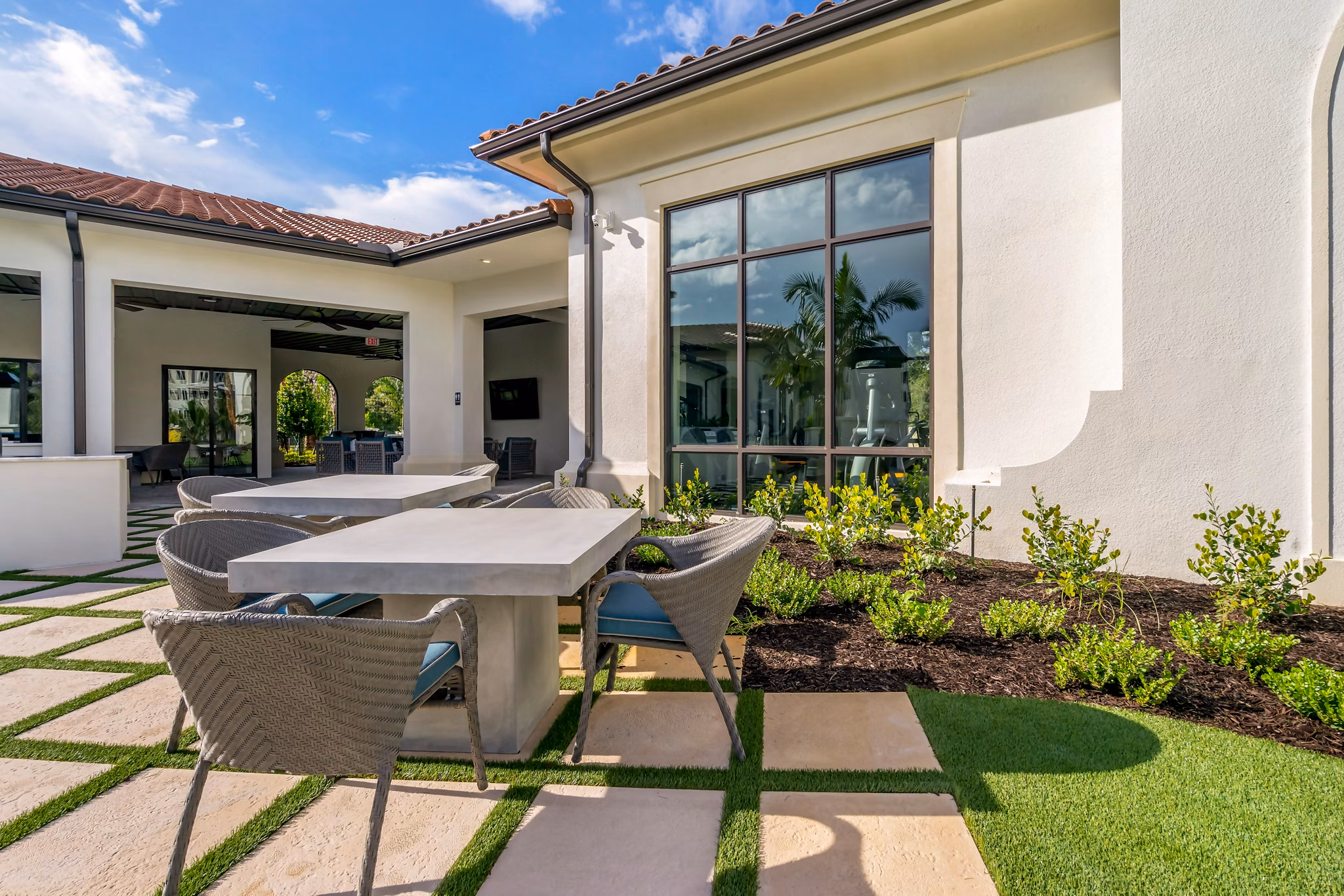 Courtyard featuring lush landscaping and seating at Lago Apartments, a luxury Greystar community