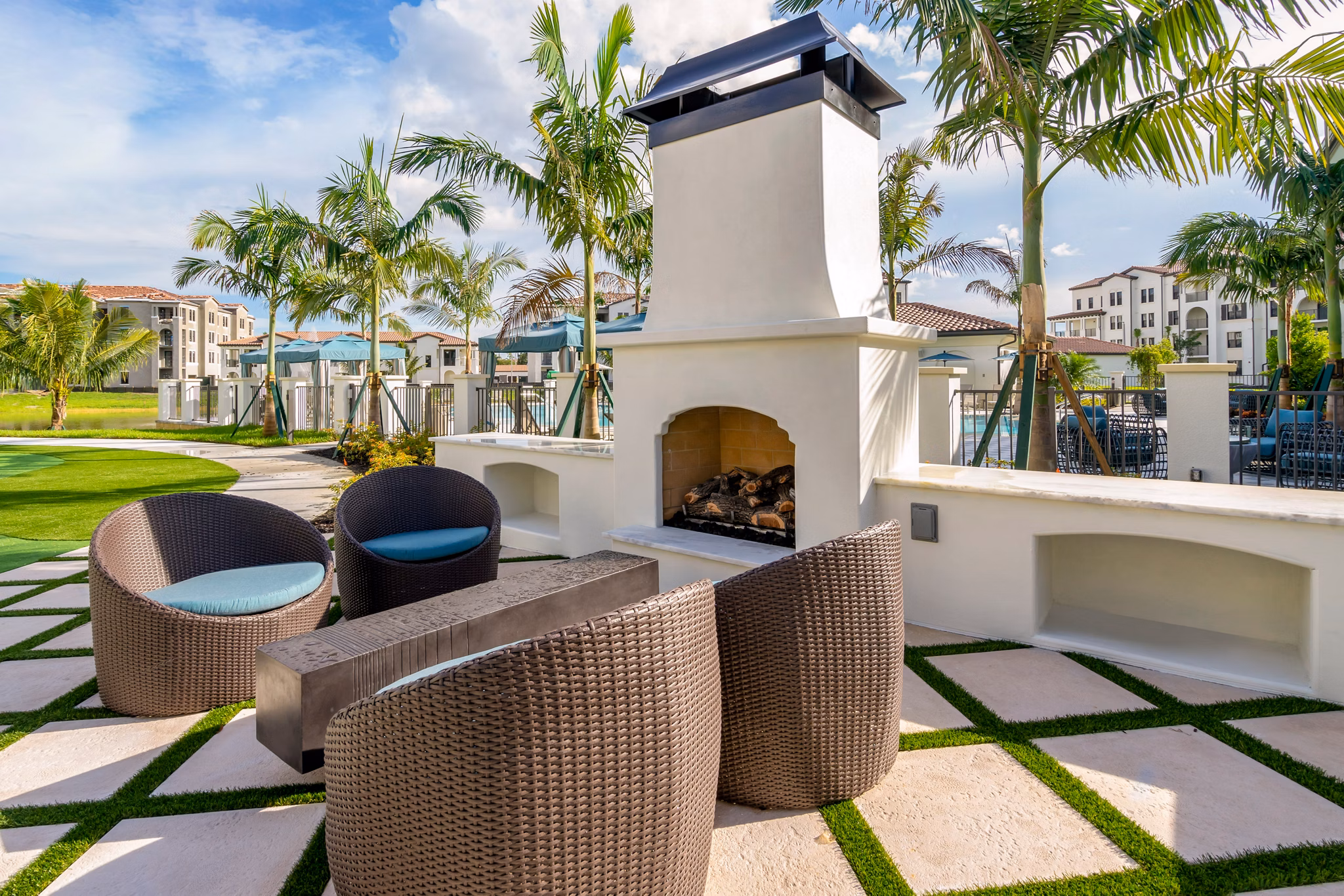 Cozy fire pit surrounded by lounge seating at Lago Apartments, perfect for social gatherings and relaxation in a luxury setting