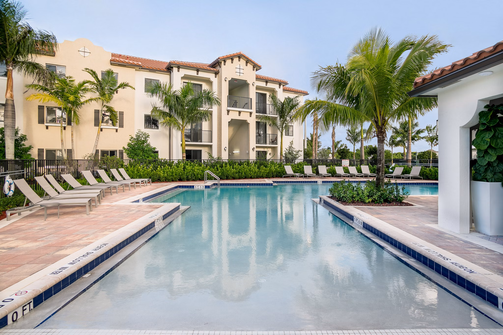 Luxurious pool area at Celebration Pointe Apartments, featuring poolside lounges and landscaped surroundings for relaxation and leisure