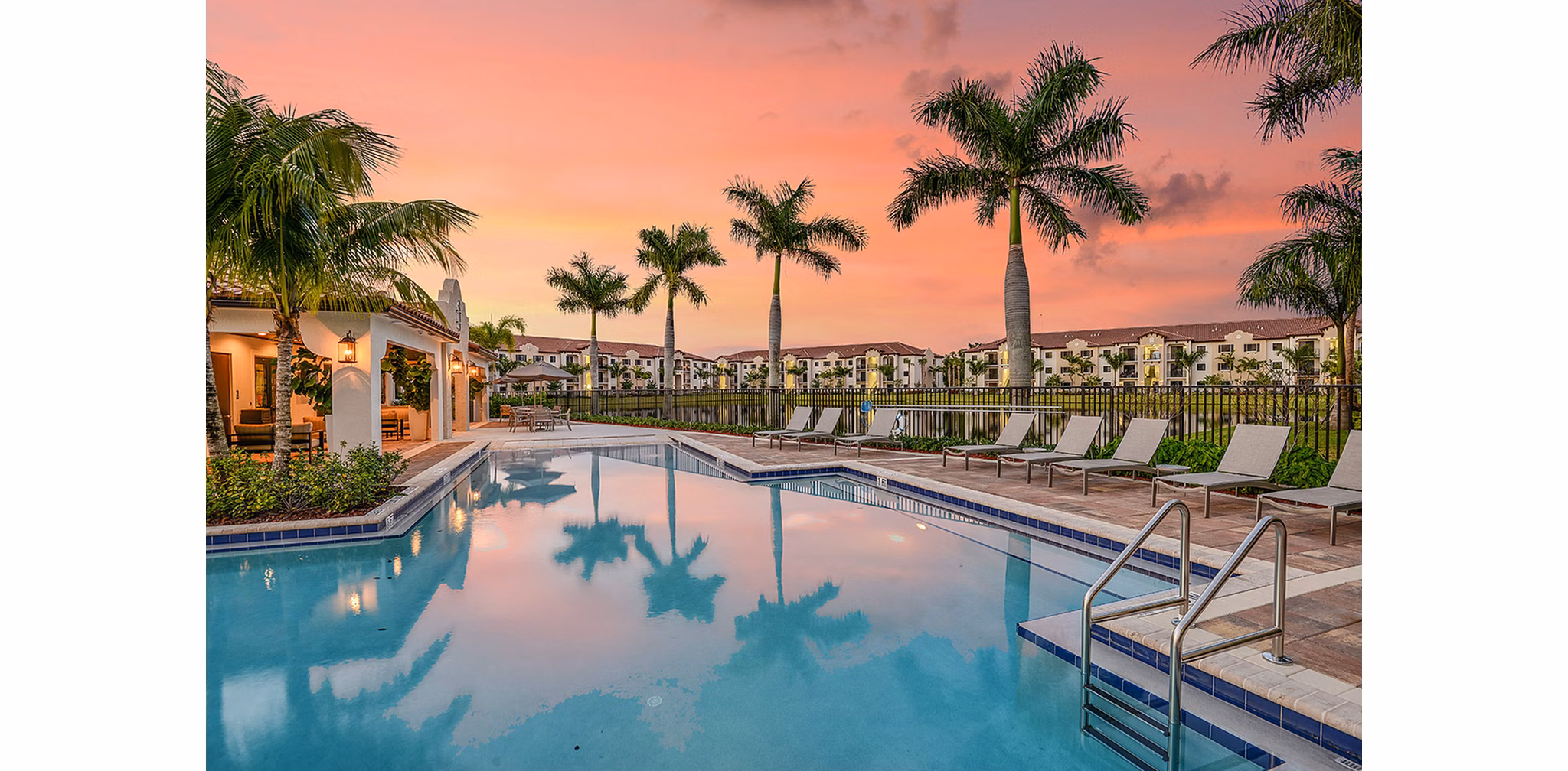 Modern outdoor pool with sun loungers at Celebration Pointe Apartments, offering luxury relaxation and leisure amenities