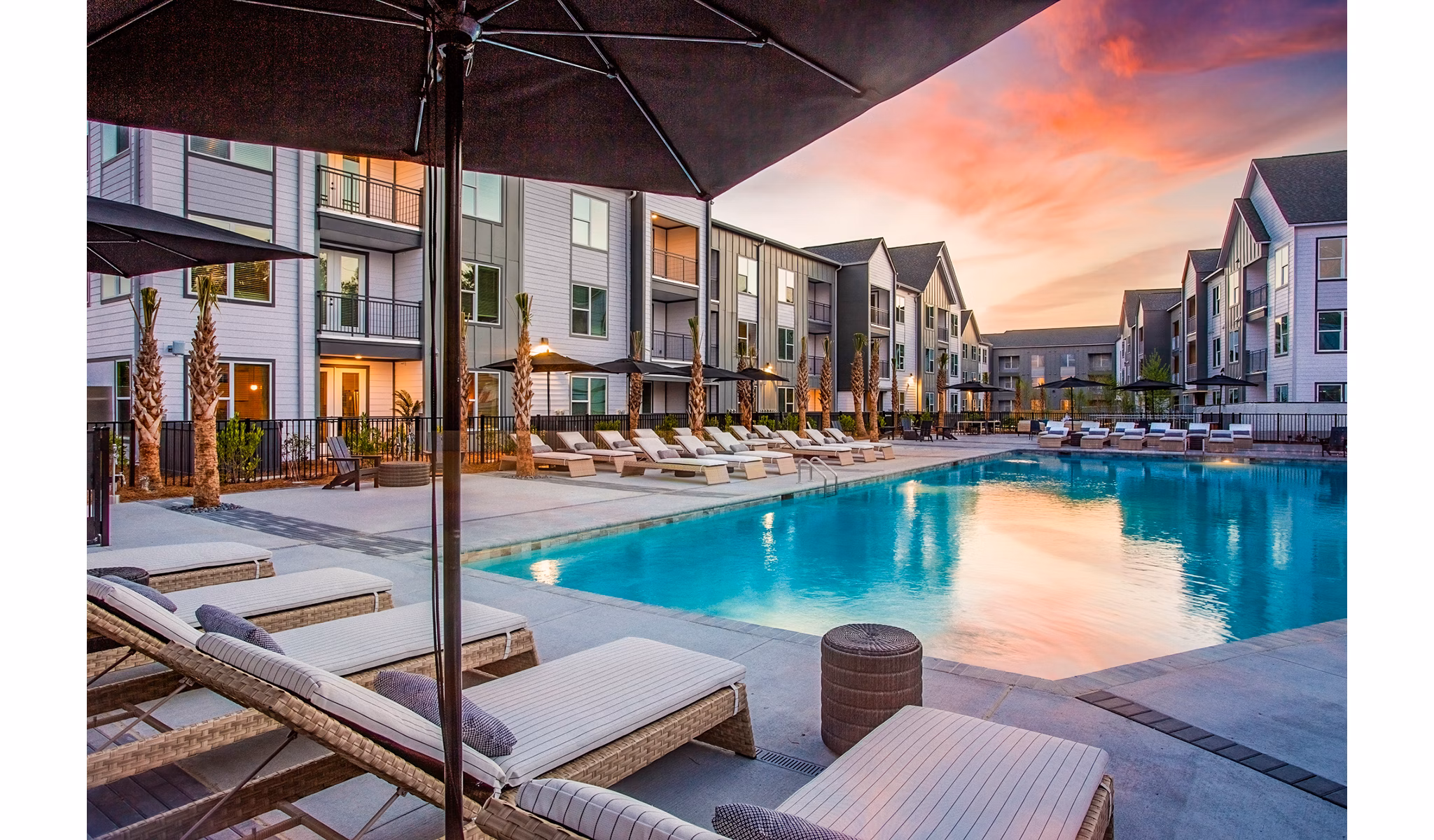 Modern pool area at The Monty Apartments featuring loungers and relaxation spaces in a luxurious setting
