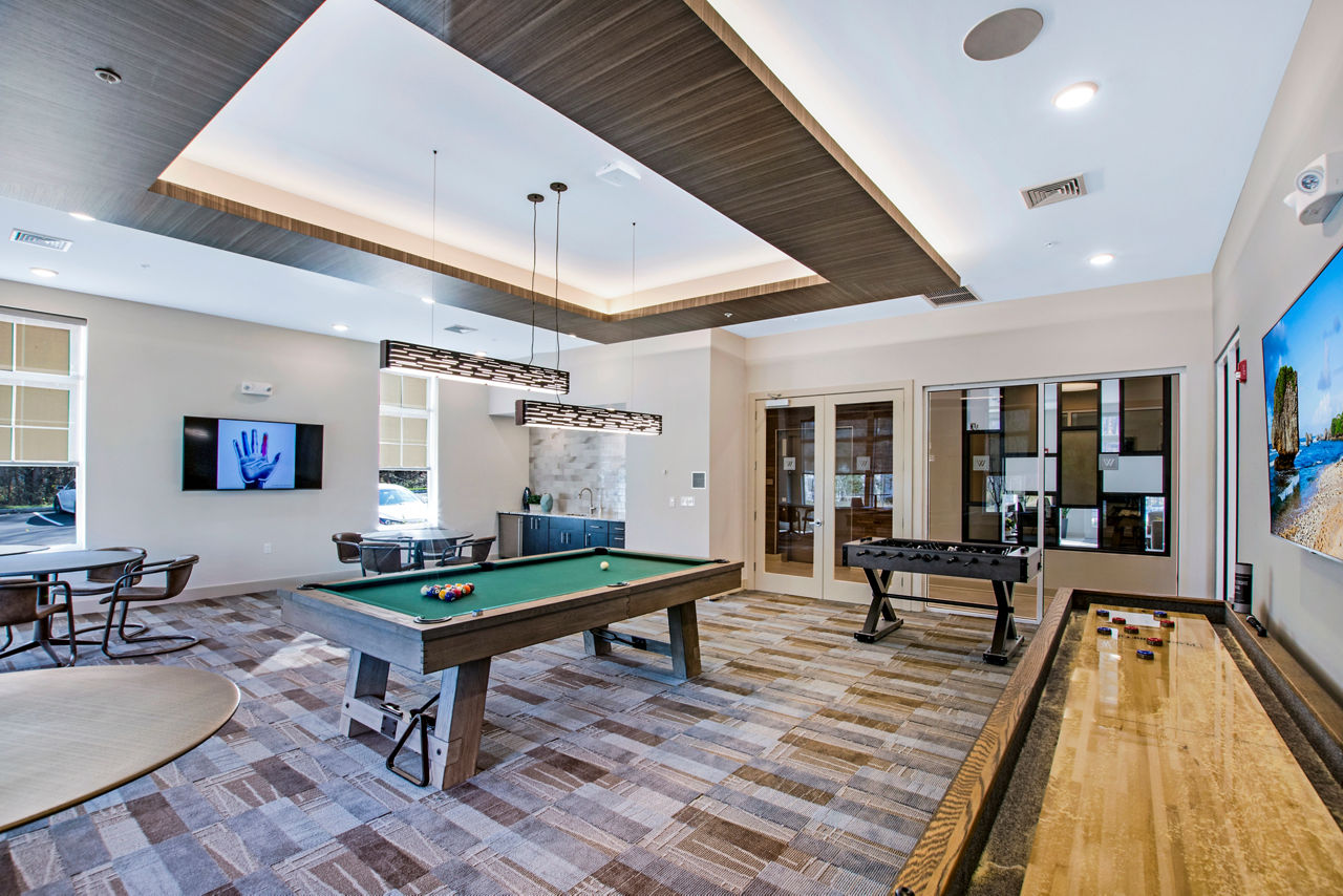 Game room with pool table and modern seating at Woodgrove at Sterlington Apartments luxury complex