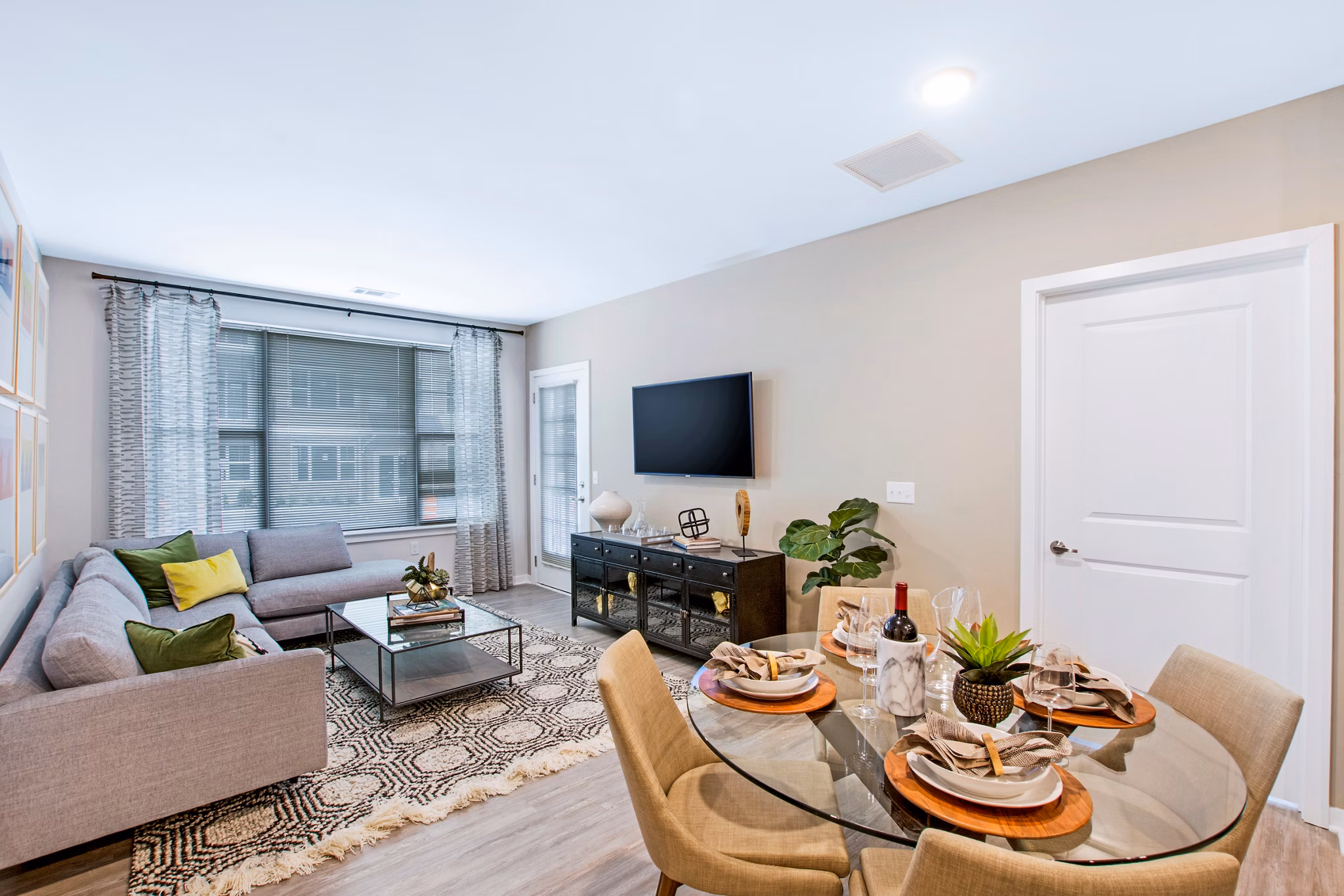 Dining room with elegant chandelier and modern furnishings at Woodgrove at Sterlington Apartments, a Greystar luxury community