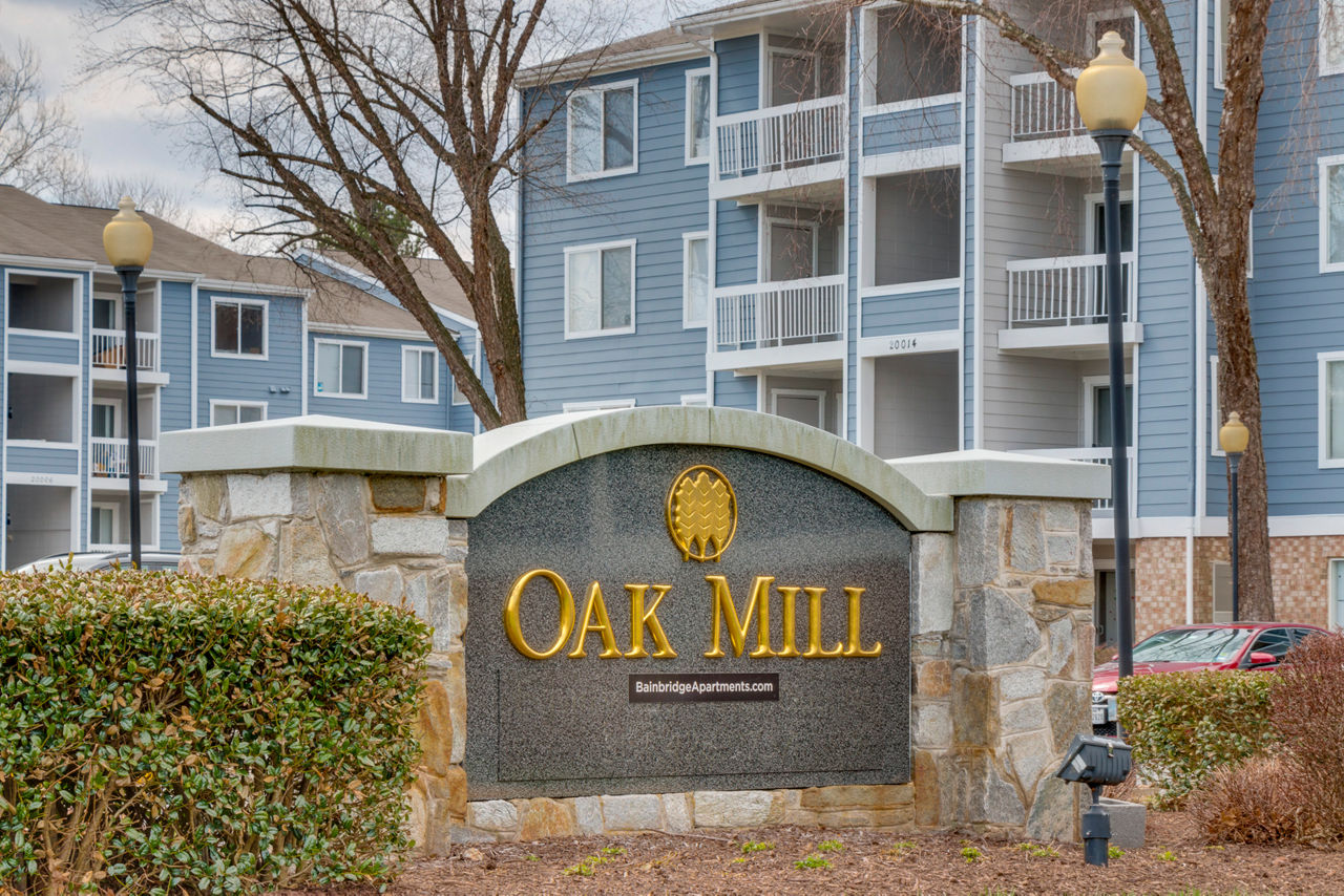 Avana Oak Mill Apartments: Elegant signage showcasing luxury living in a serene setting