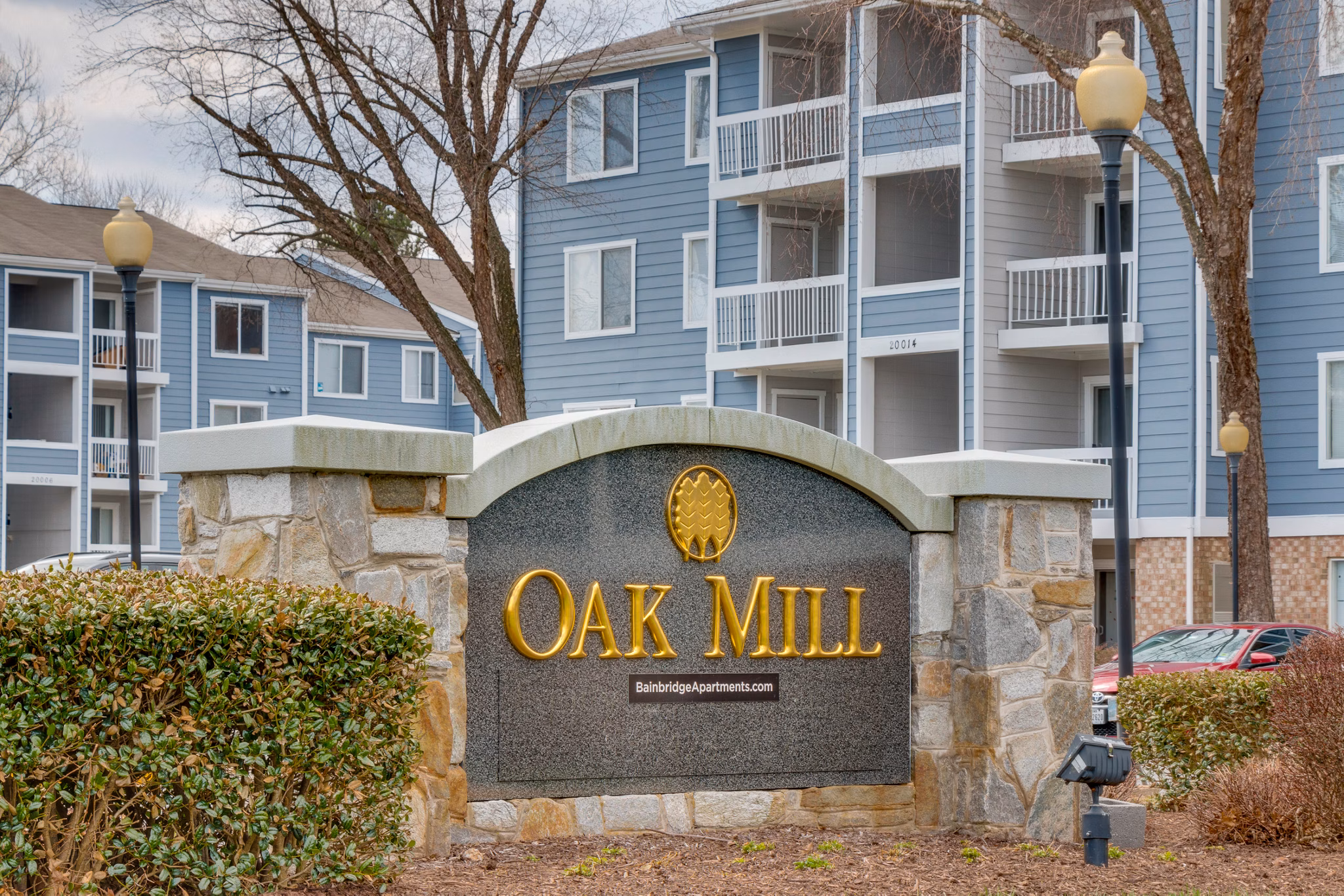 Avana Oak Mill Apartments: Elegant signage showcasing luxury living in a serene setting