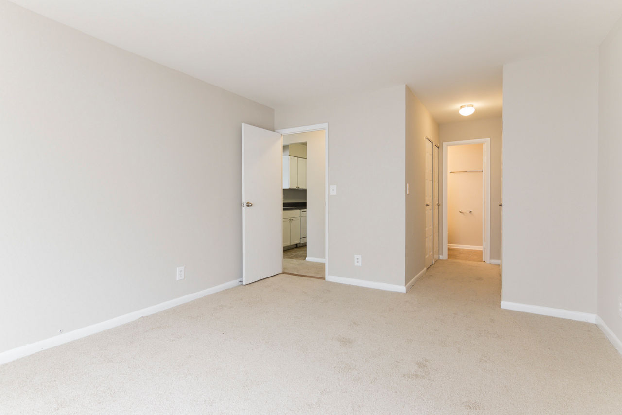 Cozy bedroom with modern decor at Avana Oak Mill Apartments, featuring natural light and elegant furnishings